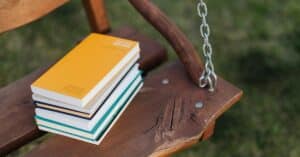 stack of poetry books on a wooden swing