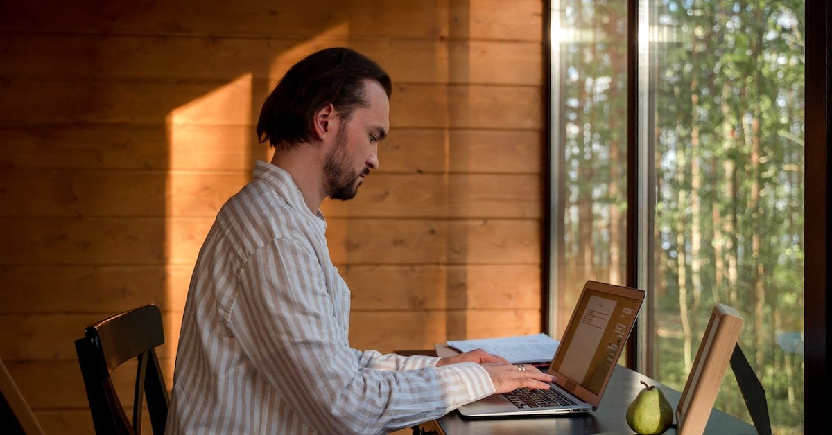 man writing an article in a room with windows