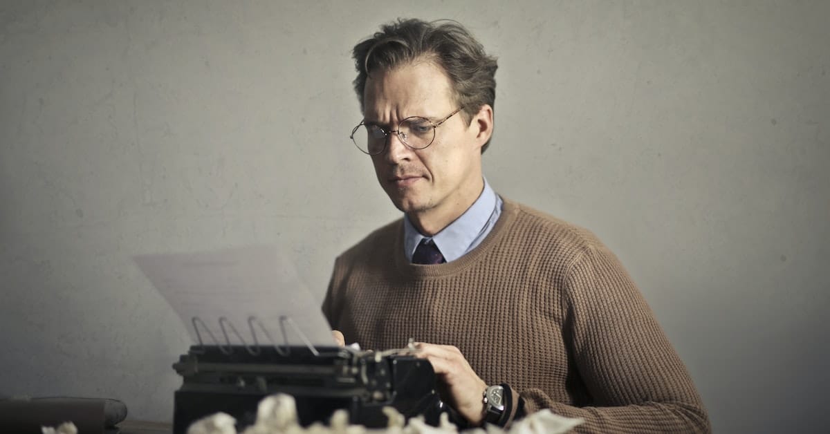 man typing on typewriter after reading writer quotes for inspiration