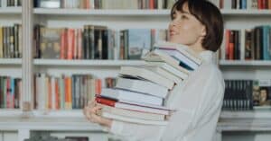 woman carrying a stack of best selling books