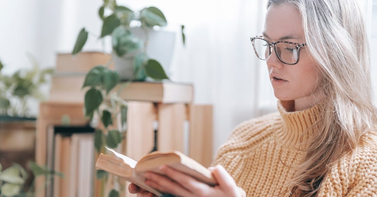 woman reading fiction book using one of the different writing styles