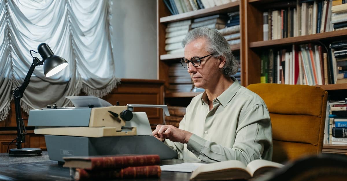 man motivated to write a book on a typewriter